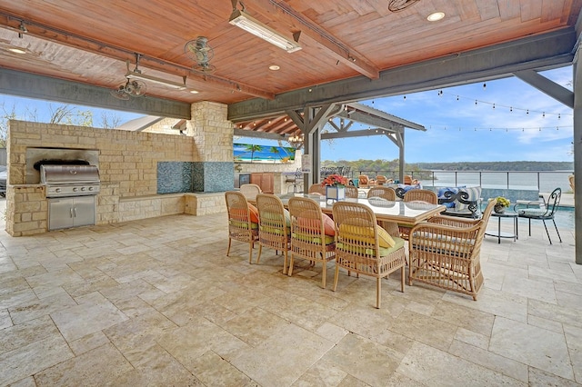 view of patio featuring grilling area, an outdoor kitchen, a bar, and outdoor dining space