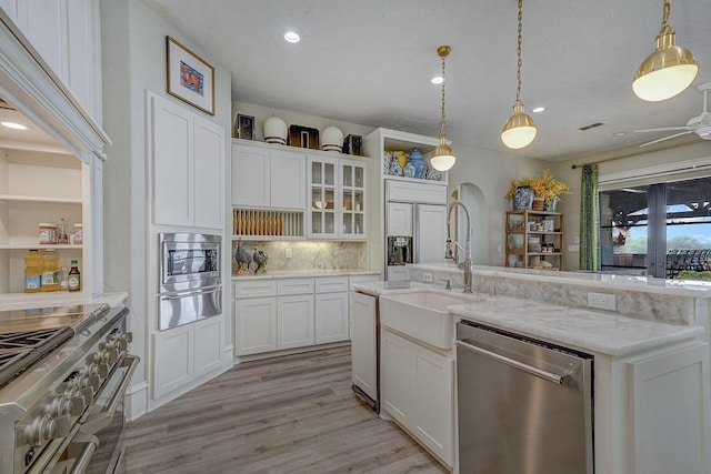 kitchen featuring backsplash, a warming drawer, appliances with stainless steel finishes, and white cabinetry
