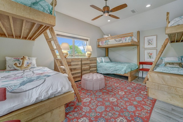 bedroom with vaulted ceiling, wood finished floors, visible vents, and recessed lighting