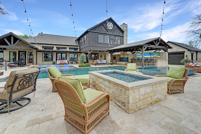 outdoor pool featuring a gazebo, an outdoor living space with a fire pit, a patio area, and an in ground hot tub