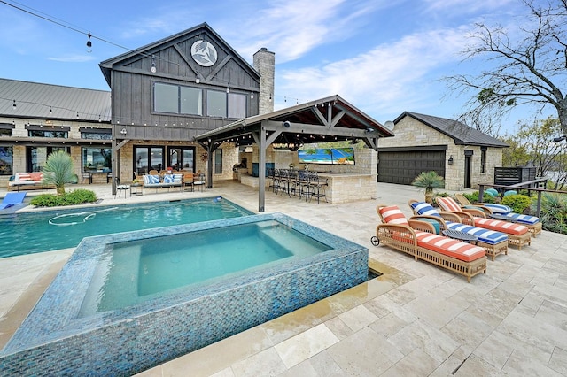 exterior space featuring outdoor dry bar, an outdoor hangout area, a patio, a gazebo, and a pool with connected hot tub