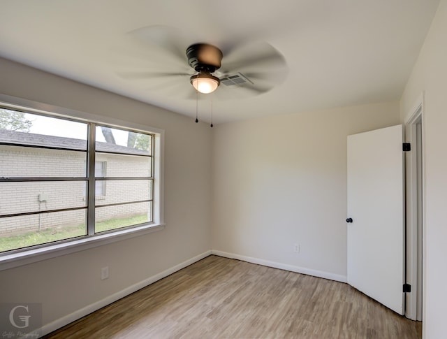 spare room featuring baseboards, a ceiling fan, and light wood-type flooring