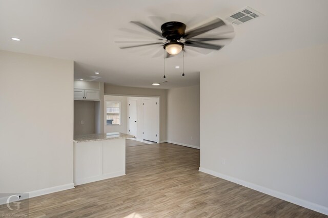 empty room with recessed lighting, light wood finished floors, visible vents, a ceiling fan, and baseboards
