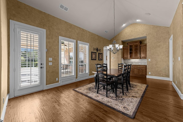 dining room featuring dark wood finished floors, vaulted ceiling, visible vents, baseboards, and a notable chandelier