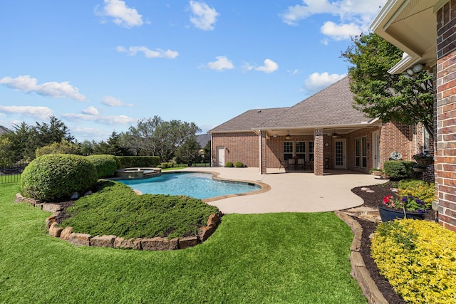 view of swimming pool featuring a patio area, a lawn, a ceiling fan, fence, and a pool with connected hot tub