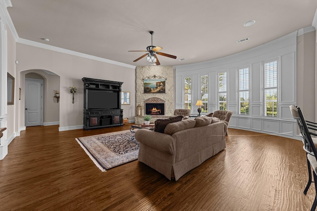 living area with a ceiling fan, visible vents, dark wood-style floors, and crown molding