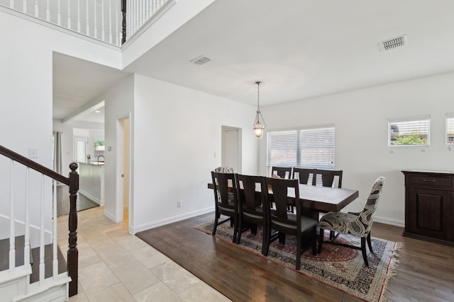 dining area with baseboards, visible vents, and stairway
