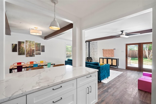 2744 Bay Meadows Ct, Farmers Branch, TX 75234 - kitchen featuring a wood stove, white cabinetry, dark wood-style flooring, light stone counters, and a ceiling fan