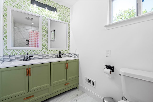 2744 Bay Meadows Ct, Farmers Branch, TX 75234 - full bath featuring double vanity, baseboards, toilet, decorative backsplash, and marble look tiles