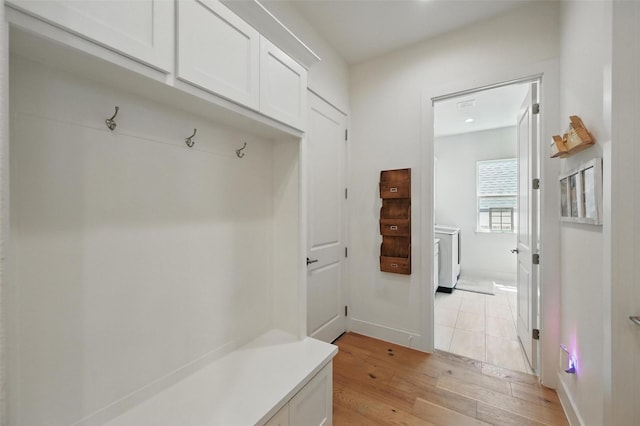 mudroom featuring baseboards, light wood finished floors, and washer / clothes dryer
