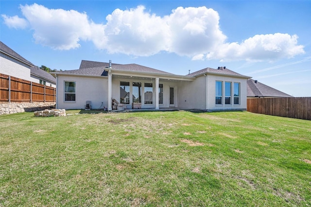 back of property with a yard, brick siding, and a fenced backyard