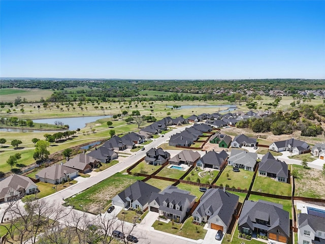 drone / aerial view with a water view, view of golf course, and a residential view