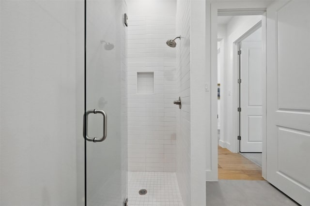 bathroom with a stall shower and wood finished floors