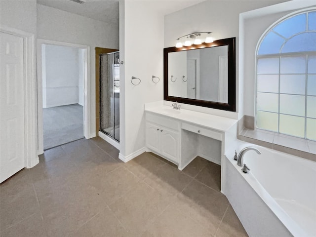 bathroom featuring tile patterned floors, baseboards, a shower stall, a garden tub, and vanity