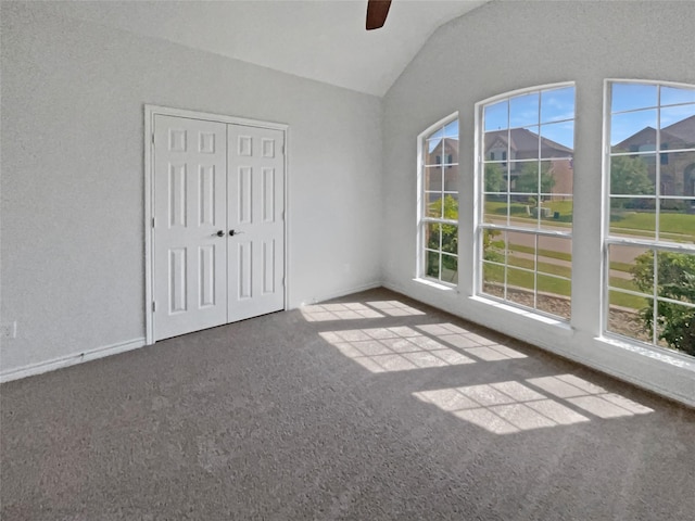 spare room featuring lofted ceiling, carpet floors, and ceiling fan
