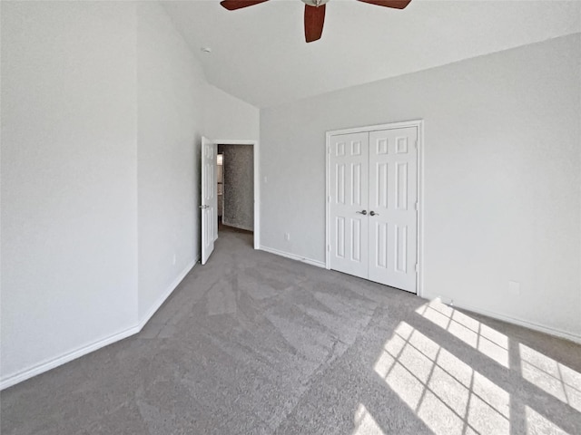 unfurnished bedroom featuring baseboards, lofted ceiling, a ceiling fan, a closet, and carpet floors
