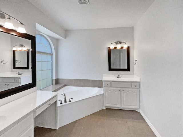 full bathroom featuring a bath, tile patterned floors, a sink, and two vanities