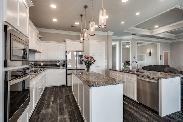 5124 Cathedral Ln, Wichita Falls, TX 76310 - kitchen with crown molding, a sink, an island with sink, appliances with stainless steel finishes, and visible vents
