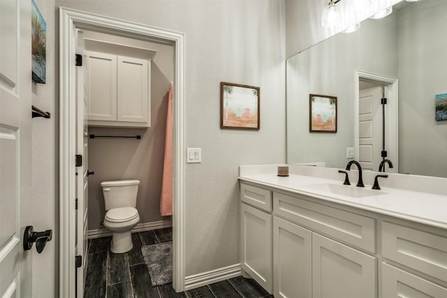 5124 Cathedral Ln, Wichita Falls, TX 76310 - bathroom featuring toilet, vanity, wood tiled floor, and baseboards