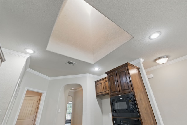 interior details featuring black microwave, visible vents, arched walkways, and ornamental molding