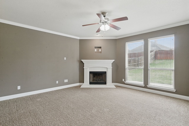 unfurnished living room with ceiling fan, carpet flooring, a fireplace with raised hearth, and ornamental molding
