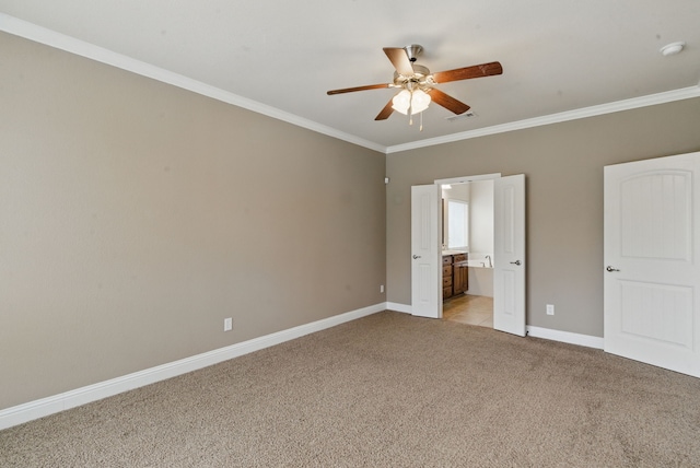 unfurnished bedroom with ensuite bathroom, visible vents, baseboards, light colored carpet, and crown molding