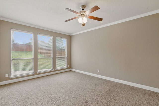 unfurnished room featuring a ceiling fan, baseboards, ornamental molding, and carpet flooring