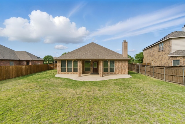 back of property with a fenced backyard, brick siding, a chimney, and a patio