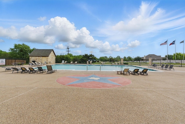 community pool with fence and a patio
