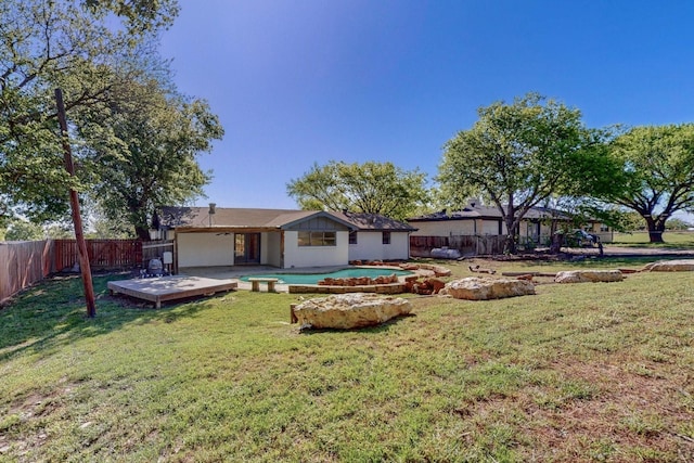 back of property featuring a fenced backyard, a wooden deck, and a yard