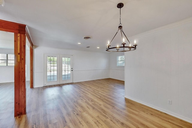 unfurnished dining area featuring baseboards, a chandelier, visible vents, and light wood-type flooring
