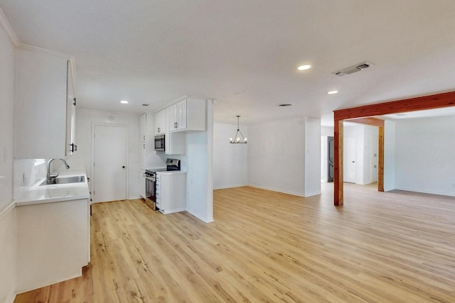 kitchen with a sink, open floor plan, range with electric stovetop, stainless steel microwave, and visible vents