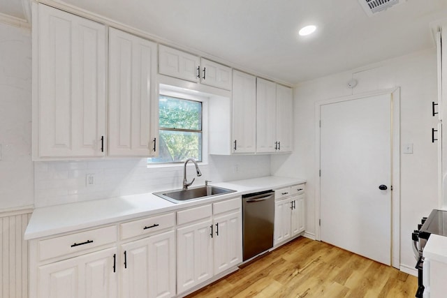 kitchen with white cabinets, light wood finished floors, a sink, visible vents, and dishwasher