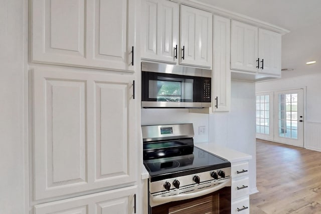 kitchen featuring stainless steel appliances, light wood finished floors, light countertops, white cabinets, and recessed lighting