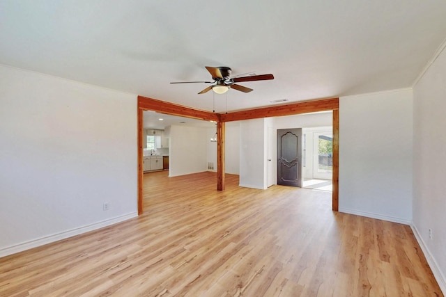 empty room with baseboards, a ceiling fan, visible vents, and light wood finished floors