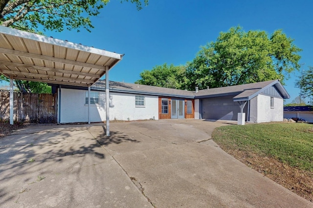 single story home with french doors, a front lawn, concrete driveway, fence, and a garage