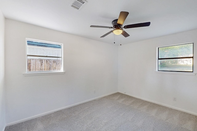 unfurnished room featuring light carpet, baseboards, visible vents, and a ceiling fan