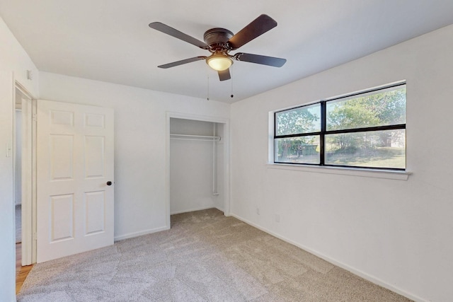 unfurnished bedroom featuring baseboards, carpet floors, a closet, and ceiling fan