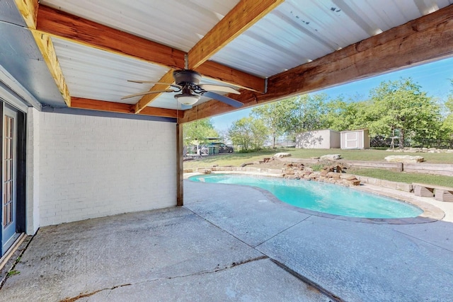 pool with a storage shed, a patio area, a ceiling fan, and an outdoor structure