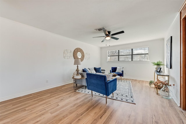 living area featuring baseboards, a ceiling fan, light wood-style floors, and visible vents