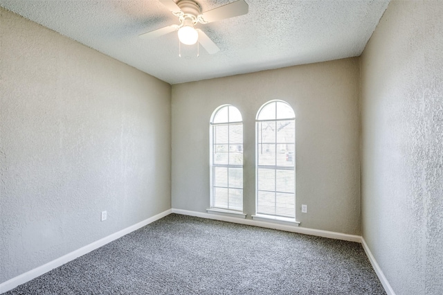 carpeted spare room featuring a textured wall, a ceiling fan, baseboards, and a textured ceiling
