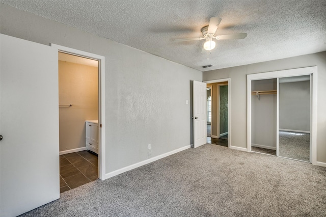 unfurnished bedroom with visible vents, carpet floors, ensuite bath, a closet, and a textured ceiling
