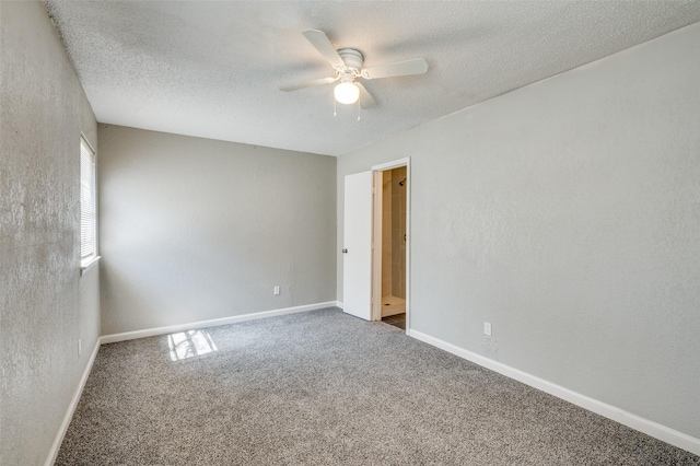 carpeted spare room featuring baseboards, a textured ceiling, and ceiling fan