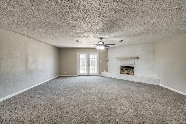 unfurnished living room featuring a textured wall, french doors, a fireplace, carpet flooring, and ceiling fan