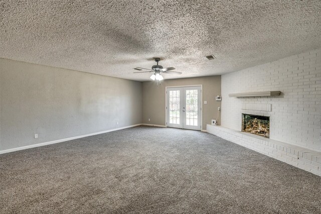 unfurnished living room featuring french doors, carpet flooring, baseboards, a ceiling fan, and a brick fireplace