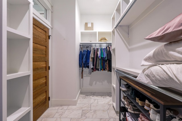 walk in closet with marble finish floor