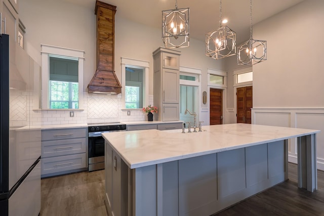 kitchen featuring dark wood finished floors, a chandelier, decorative backsplash, stainless steel range with electric stovetop, and gray cabinets