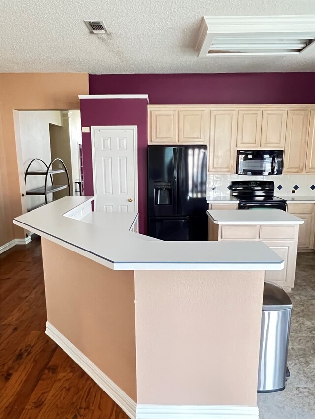 2210 Fairlands Dr, Garland, TX 75040 - kitchen with a center island, a textured ceiling, black appliances, light countertops, and visible vents
