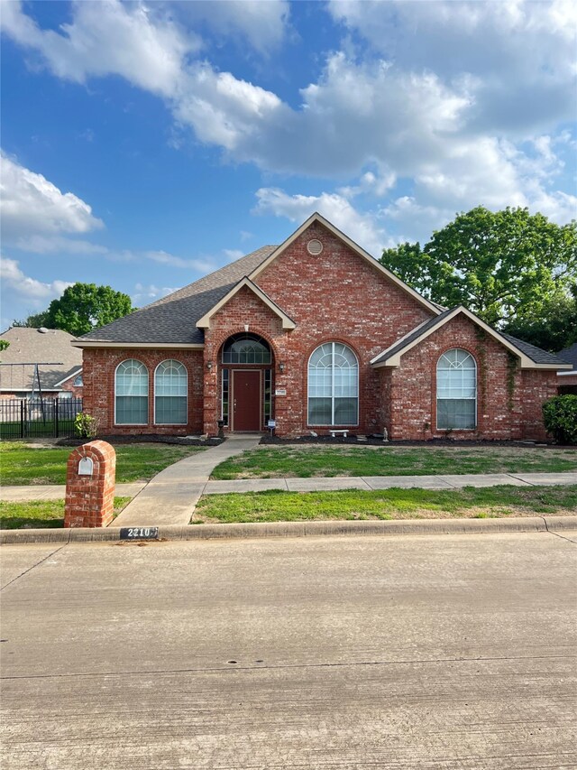 2210 Fairlands Dr, Garland, TX 75040 - view of front of property featuring brick siding, roof with shingles, a front yard, and fence