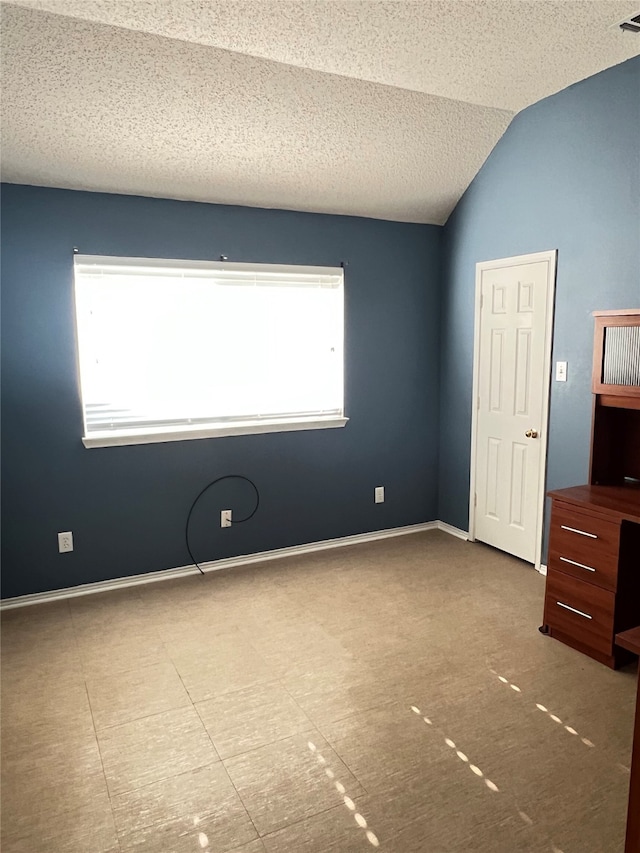 2210 Fairlands Dr, Garland, TX 75040 - unfurnished bedroom featuring lofted ceiling and a textured ceiling